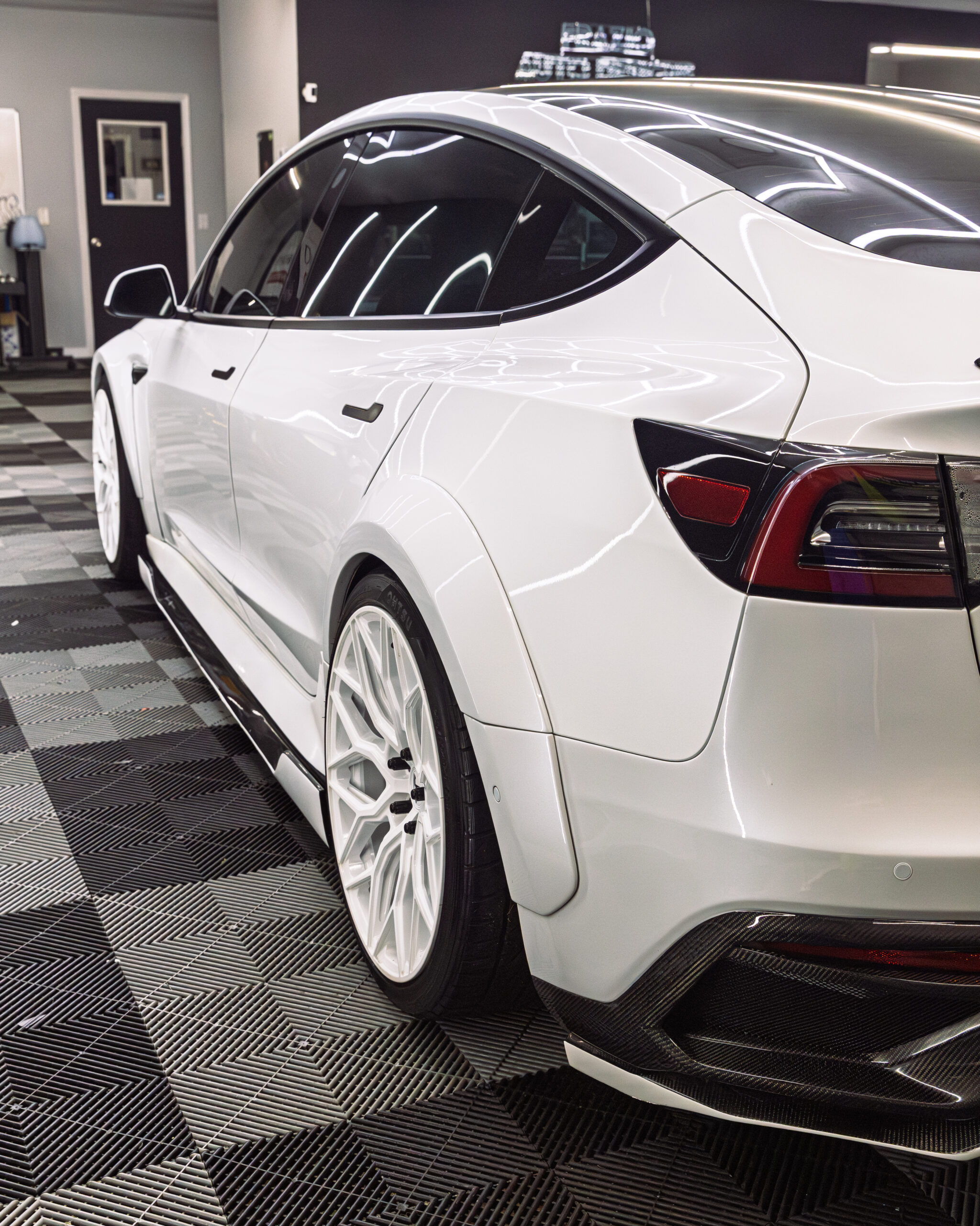 White performance vehicle inside Frazio Auto Designs shop with premium window tint