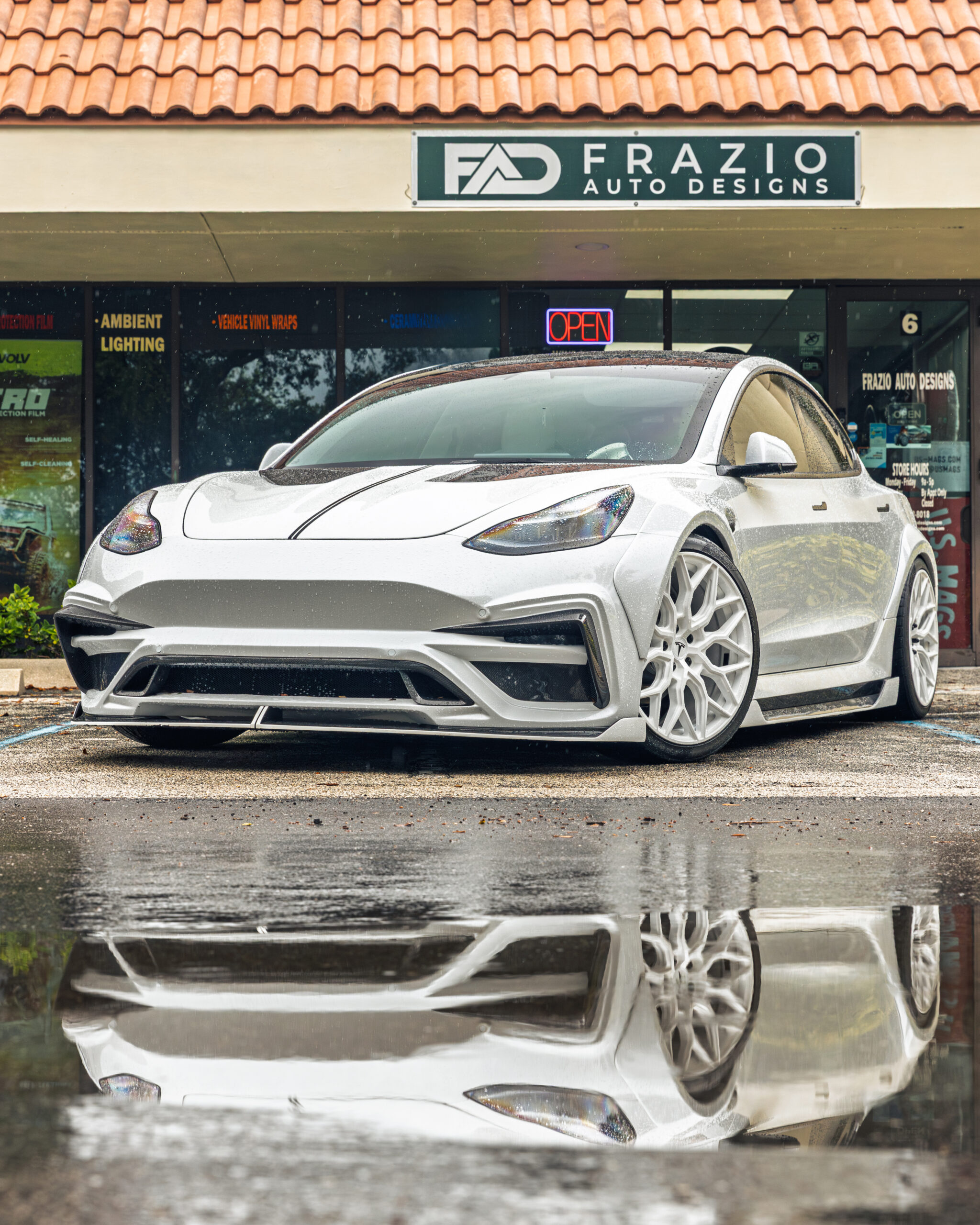 White Tesla in front of Frazio Auto Designs shop